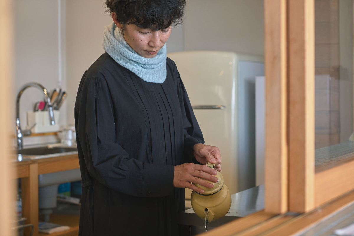 muucの服を着て室内で過ごすモデル