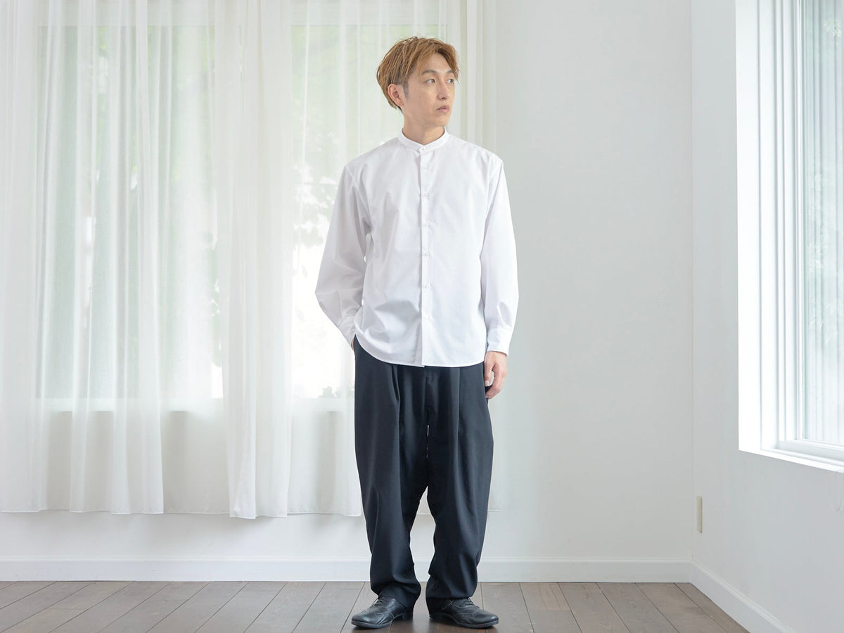 仕事中に白いスタンドカラーシャツを着る男性